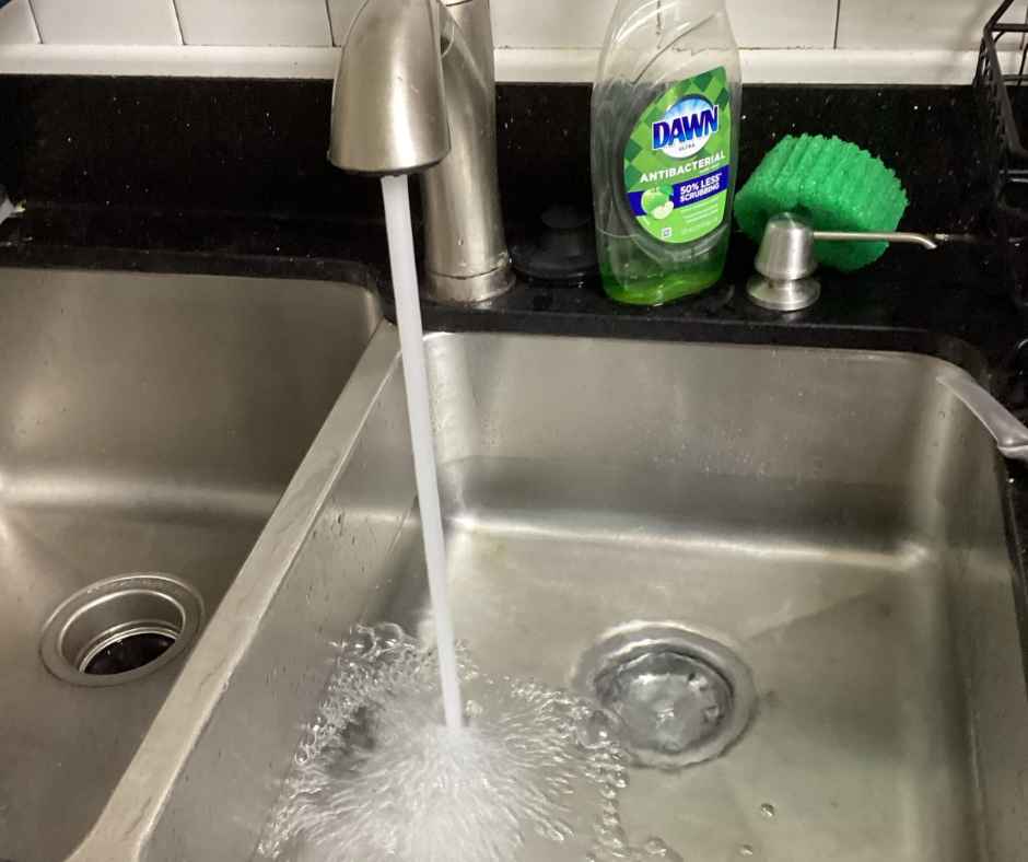A kitchen sink running water for a flood test