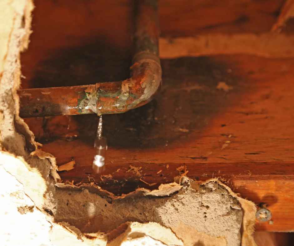 A plumbing leak revealed behind a damaged wall